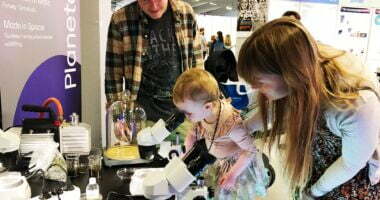 Lille pige kigger i mikroskop ved Planetariets stand
